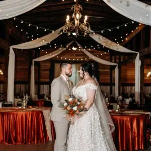 Wedding couple standing in barn wedding venue.