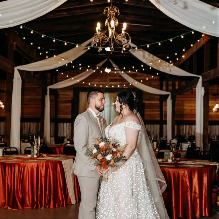 Wedding couple standing in barn wedding venue.
